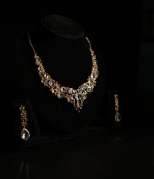 Luxury crystal bridal necklace set with teardrop stones and matching drop earrings in gold-tone finish