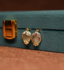 Gold tulip hook drop earrings with opalescent moonstone cabochon and crystal petal crown displayed on teal velvet jewellery box – D2Dazzle fashion jewellery India