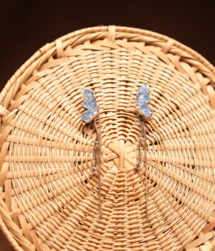 Blue crystal butterfly stud earrings with silver box chain and star drop charm displayed on wicker basket – D2Dazzle fashion jewellery India