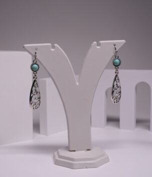 Oxidised silver-tone teardrop drop earrings with round turquoise stone and intricate filigree swirl design, displayed on a white earring stand
