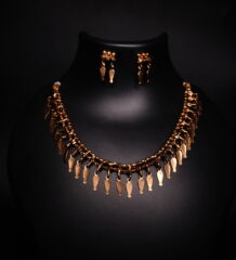 Antique gold plated necklace and earrings set with cascading leaf-shaped drops on a woven beaded chain, displayed on a black jewellery bust.