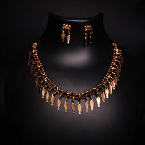 Antique gold plated necklace and earrings set with cascading leaf-shaped drops on a woven beaded chain, displayed on a black jewellery bust.