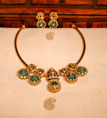 Antique kundan necklace set with peacock motifs and emerald green floral pendants, paired with matching peacock stud earrings.