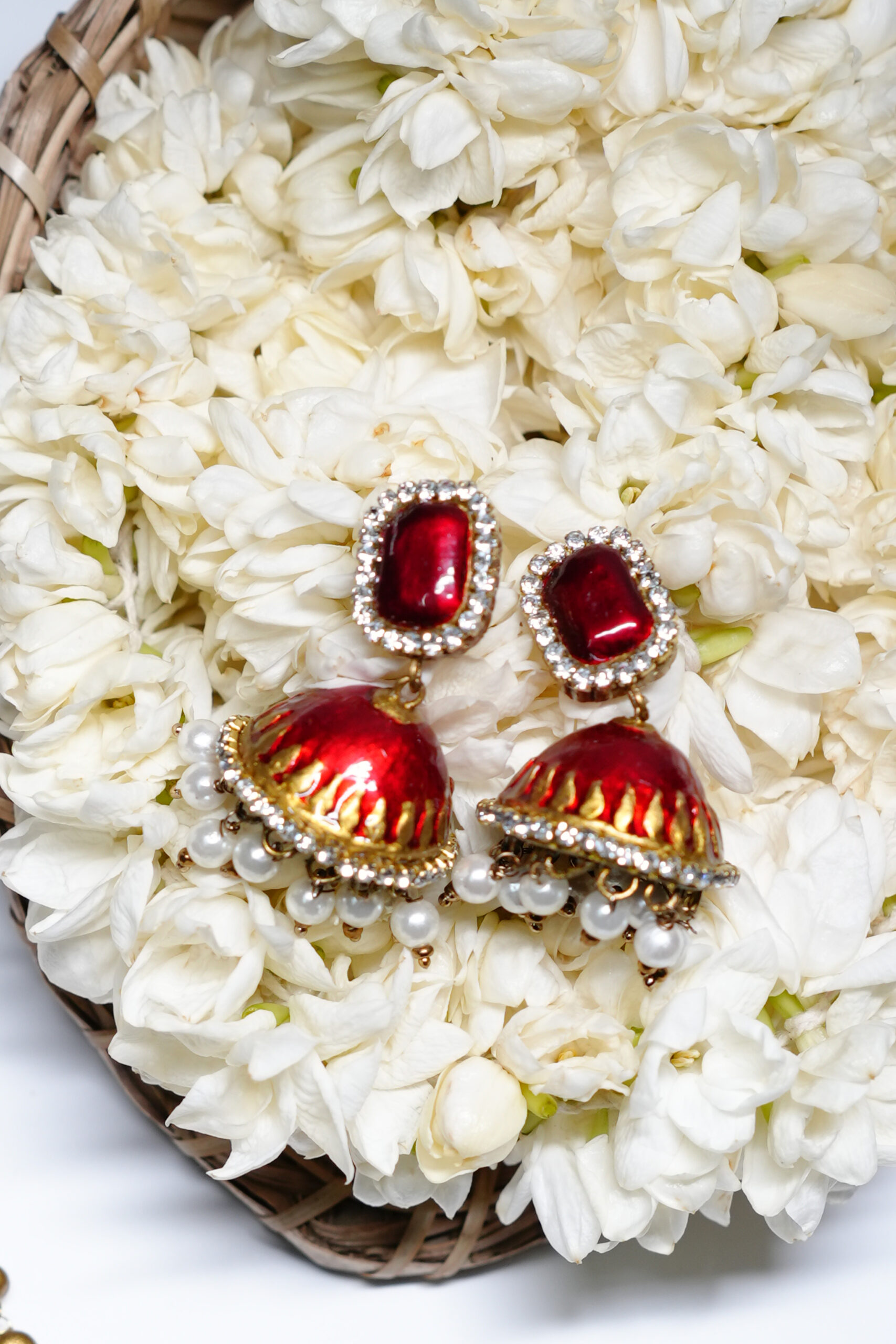 Close-up of kundan pendant necklace set showing red centre stone, gold beads, and pearl drop detailing.