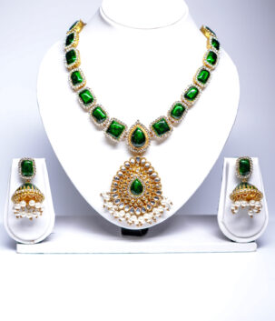Gold plated bridal necklace set with emerald-green kundan stones and pearl-fringed pendant, paired with matching jhumka earrings.