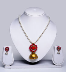 Pearl beaded necklace with a coral-pink floral pendant and gold jhumka drop, paired with matching stud earrings, displayed on a white jewellery bust.