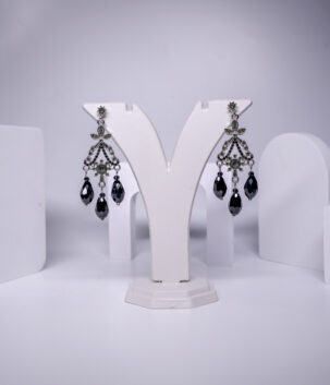 black crystal chandelier earrings featuring floral detailing and faceted teardrop beads, displayed on a jewellery stand.