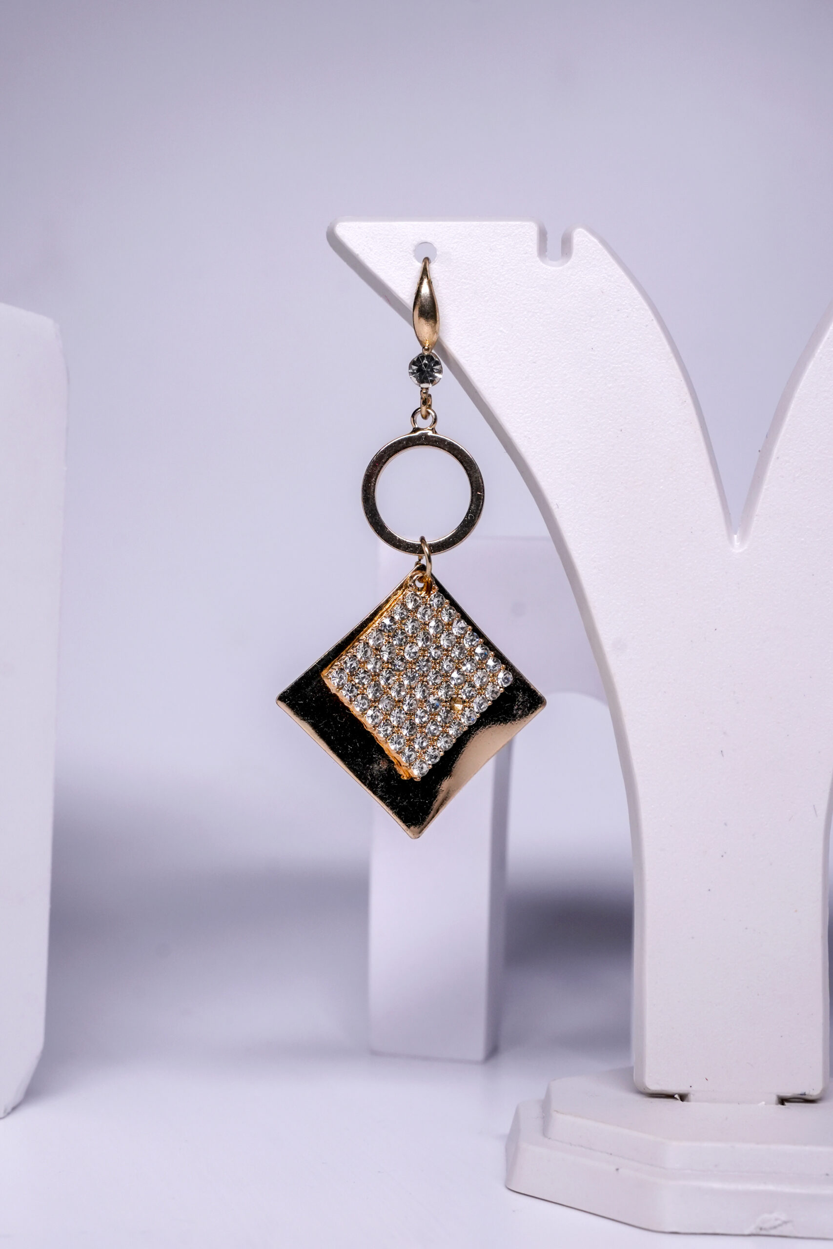Close-up view of gold plated black enamel earrings showing the crystal pavé detailing and circular link design.