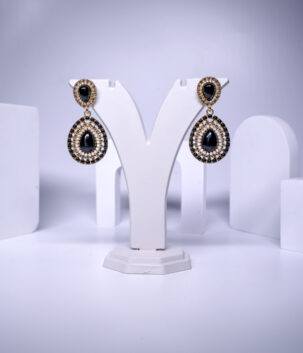 Black stone teardrop earrings featuring beaded and crystal halo detailing, displayed on a jewellery stand.