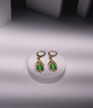 Gold plated drop earrings with green jade-toned stones and sparkling CZ detailing, displayed on a white jewellery stand.