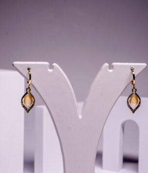 Gold plated marquise drop earrings with a citrine stone and crystal detailing, displayed on a white jewellery stand.