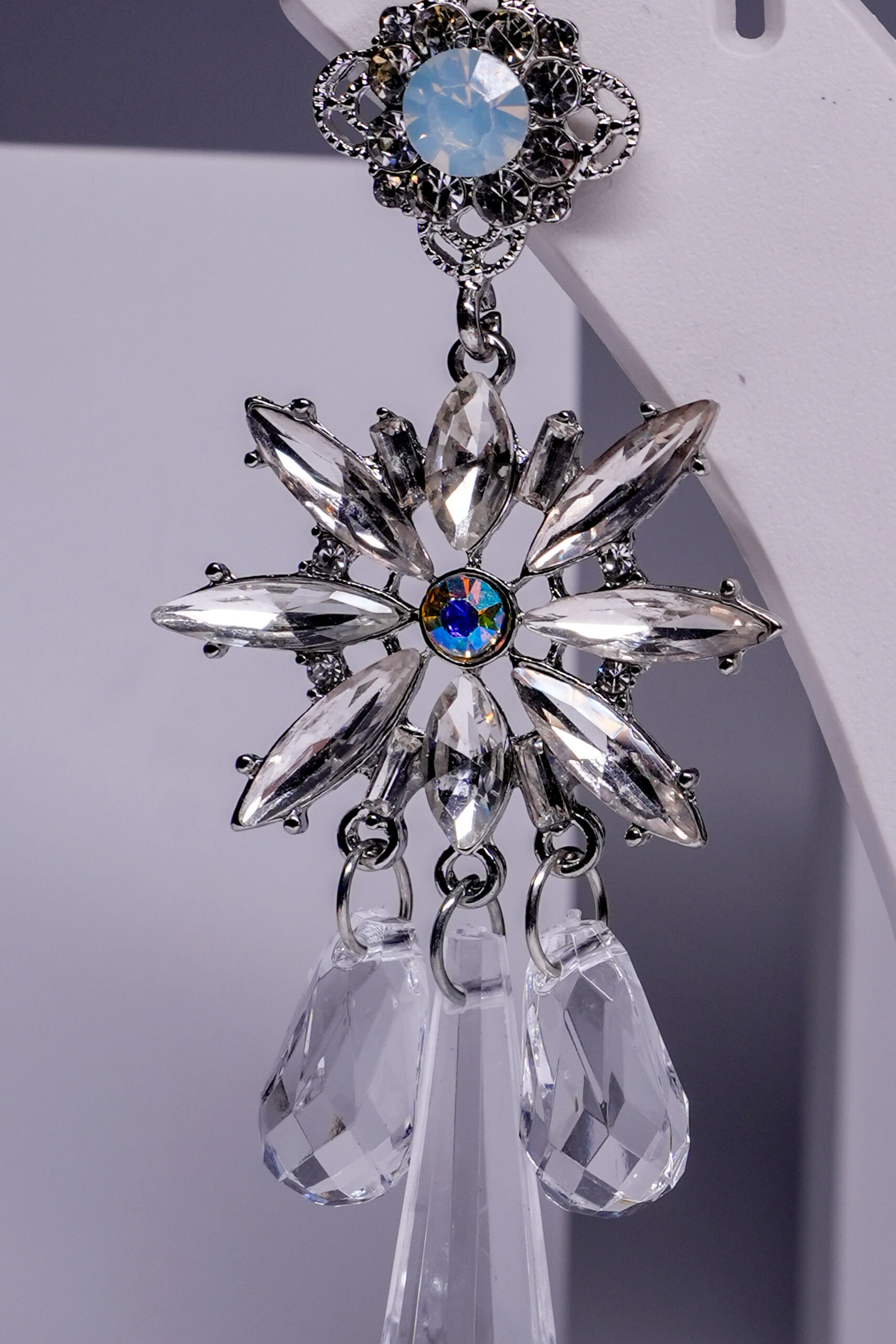 Close-up of silver plated crystal star earrings showing marquise stone detailing and faceted drop crystals.