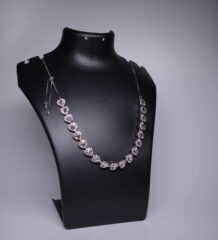 Silver rhodium plated necklace with heart-shaped pink stones and sparkling halo settings, displayed on a black jewellery bust.
