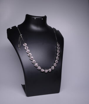 Silver rhodium plated necklace with heart-shaped pink stones and sparkling halo settings, displayed on a black jewellery bust.
