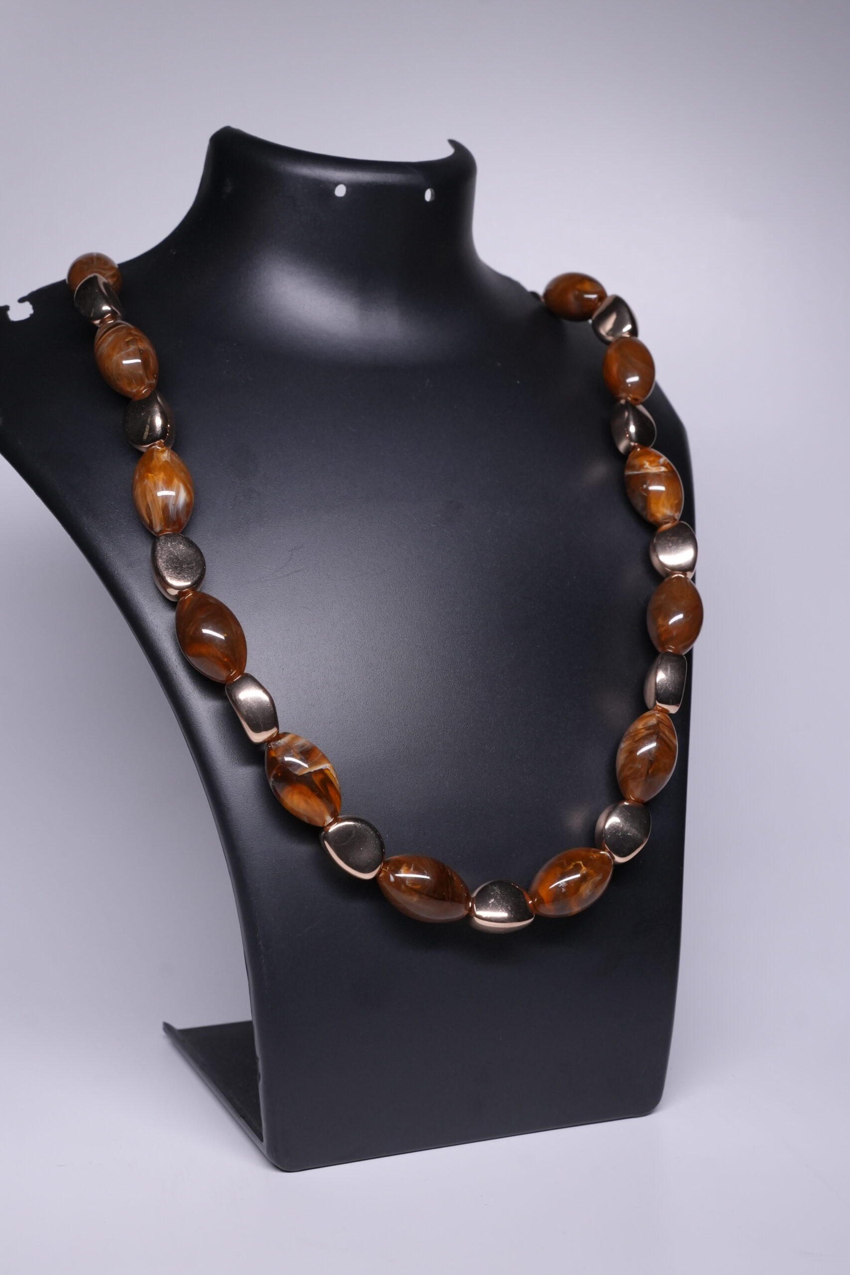 Close-up of tiger's eye beaded necklace showing tumbled amber stones and gold plated accent beads.