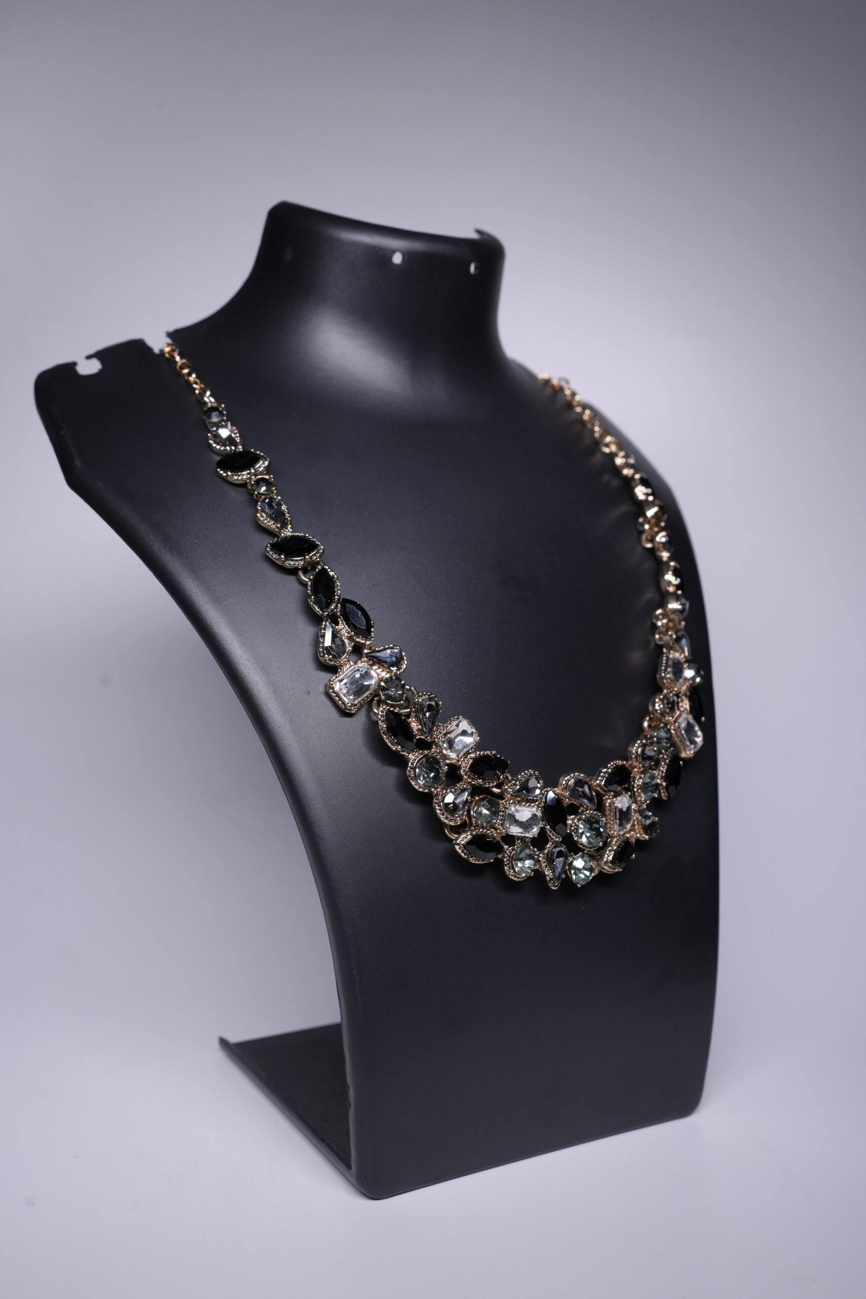 Close-up of gold plated statement necklace showing black crystal cluster design and gold detailing.