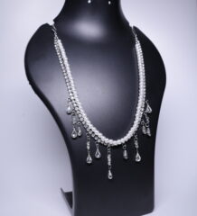 A silver plated double-strand necklace with white pearls and sparkling crystal drops, displayed on a black jewellery bust.