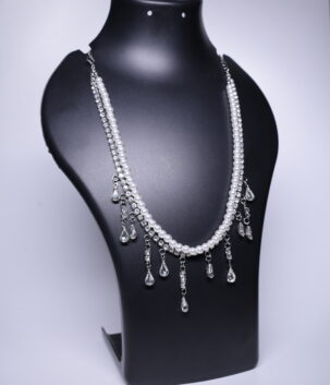 A silver plated double-strand necklace with white pearls and sparkling crystal drops, displayed on a black jewellery bust.