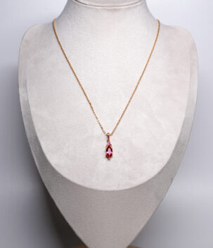 Ruby Pink Zircon Pendant Necklace with a marquise-cut ruby-pink zircon accents on a fine chain, displayed on a grey bust stand.