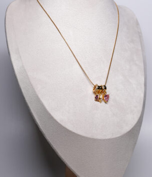 Gold plated snake chain necklace from d2dazzle with pink and lilac zircon heart charms and a gold star charm on sparkling rings, shown on a grey bust stand.