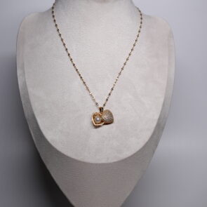 Gold plated heart pendant necklace from d2dazzle with a sparkling pavé zircon heart and an open heart holding a white pearl, on a fine gold sparkle chain displayed on a grey bust stand.