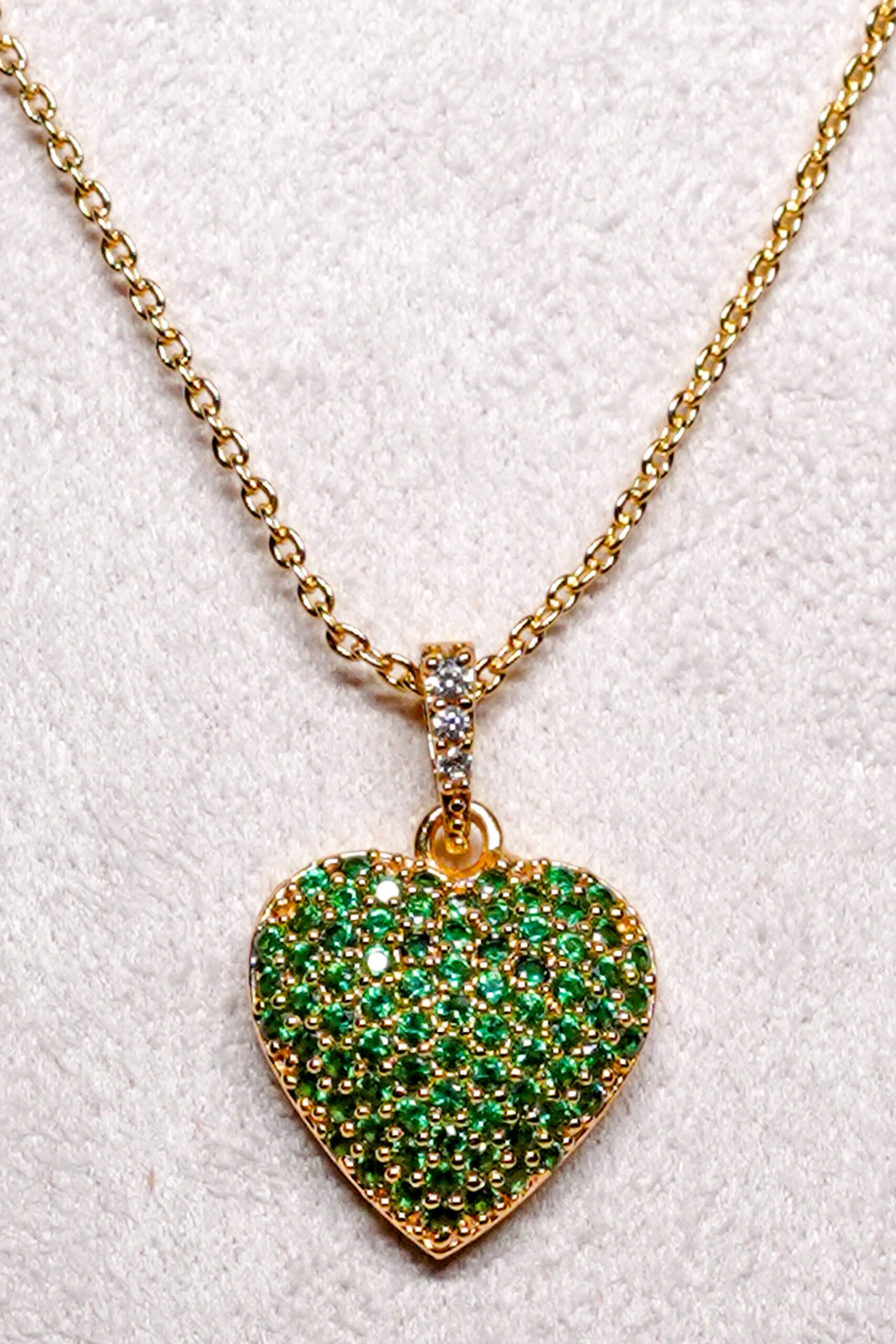 Close-up of the green pavé zircon heart pendant with white zircon bail from D2Dazzle